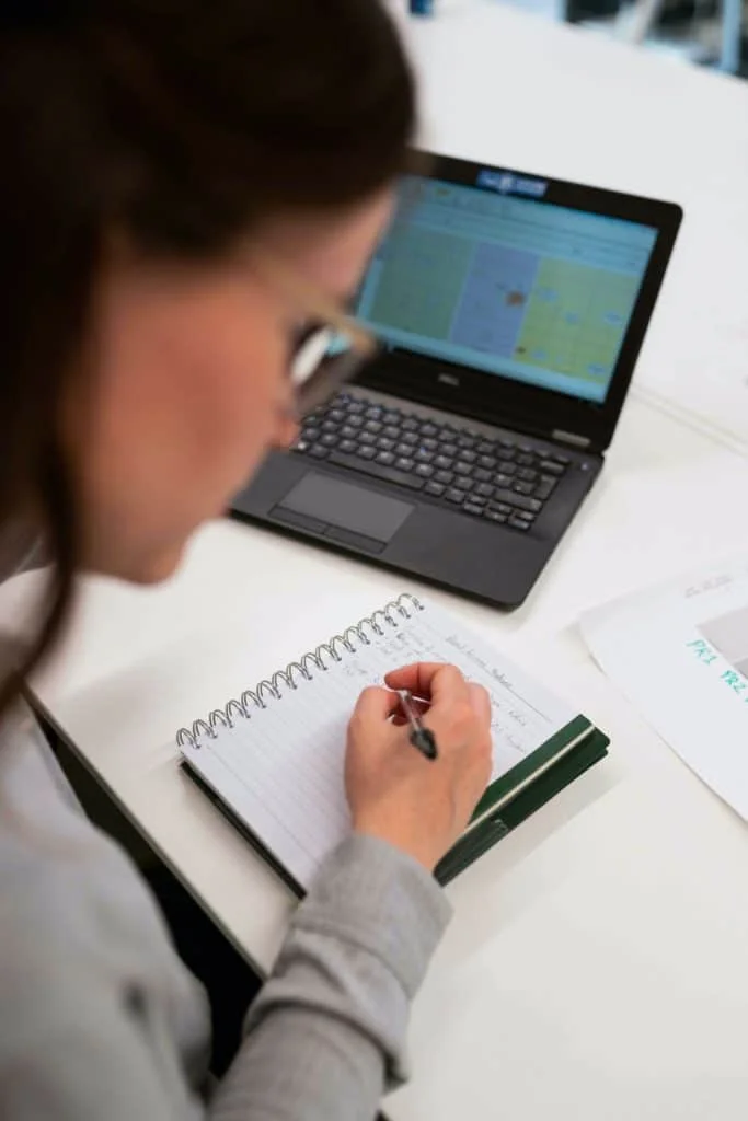 Woman writing in a notebook at a desk