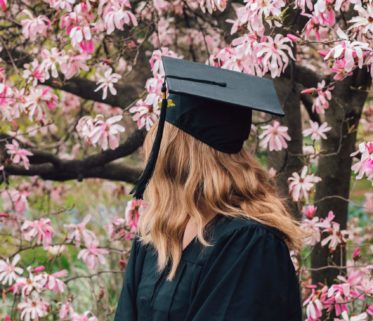Graduate stood under the cherry blossom