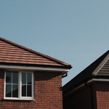 Roof and window of red brick new build homes