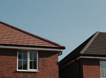 Roof and window of red brick new build homes